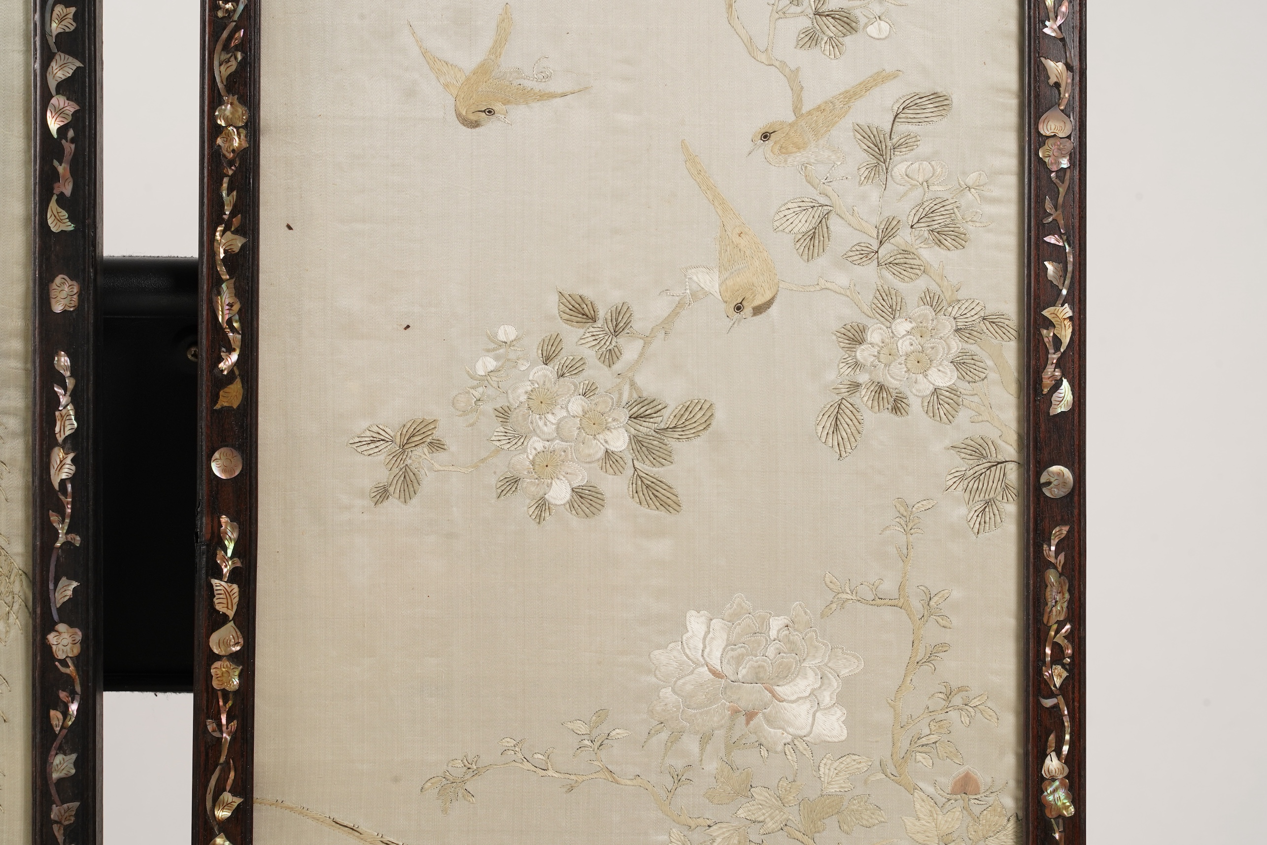 A pair of Chinese embroidered silk ‘bird’ panels, in mother-of-pearl inlaid hongmu frames, late 19th/early 20th century